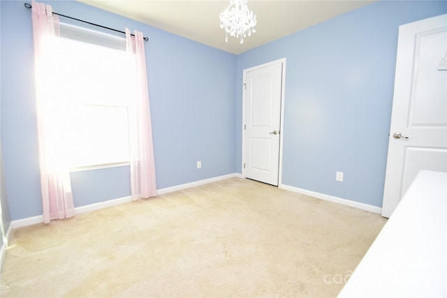 unfurnished bedroom featuring light carpet and a notable chandelier