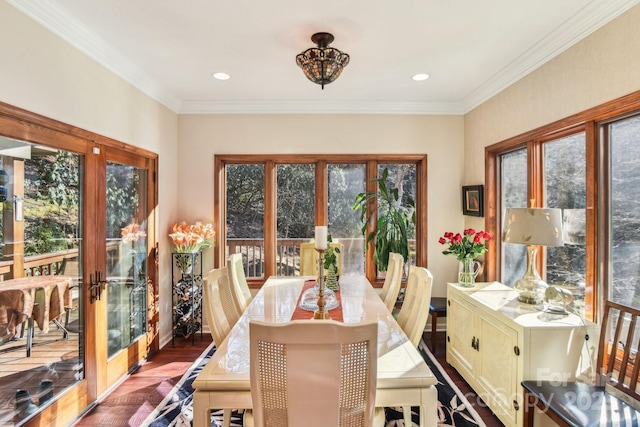 dining room with ornamental molding, plenty of natural light, and wood finished floors