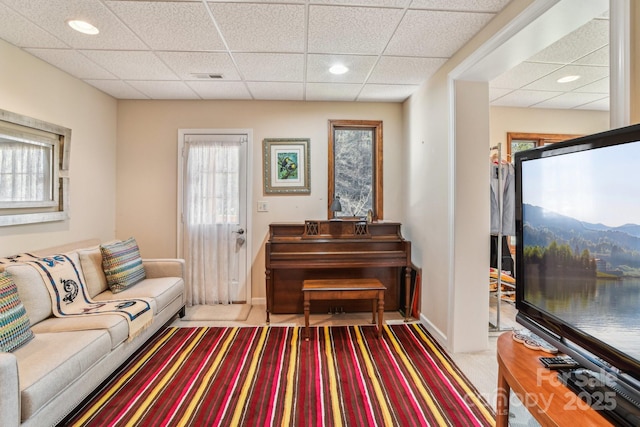 living room featuring a paneled ceiling, recessed lighting, light colored carpet, visible vents, and baseboards