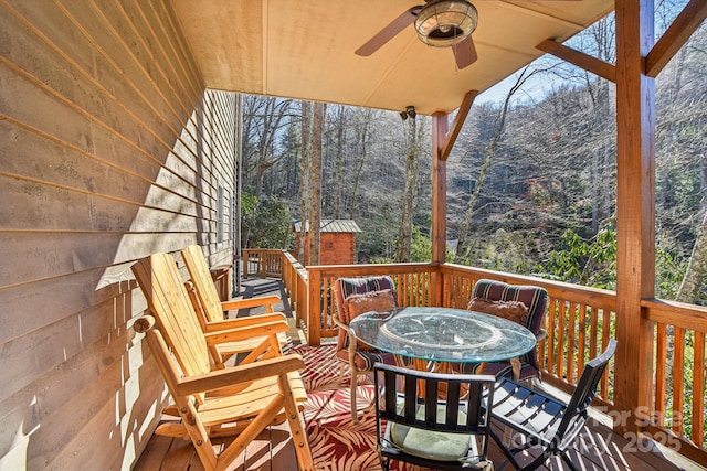 deck with outdoor dining space and a ceiling fan