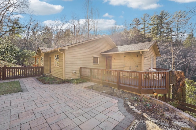 rear view of house featuring a deck and a patio area