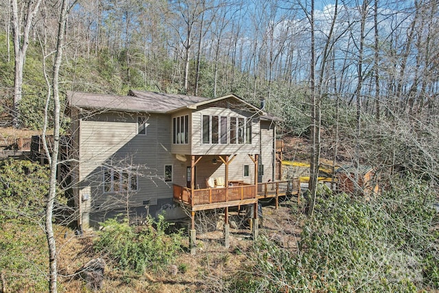 back of house with crawl space and a wooden deck