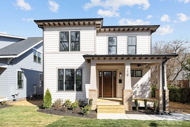 view of front of house with covered porch, a front yard, and ceiling fan