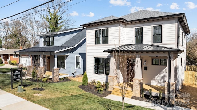 view of front of property with a porch, metal roof, a front yard, and roof with shingles