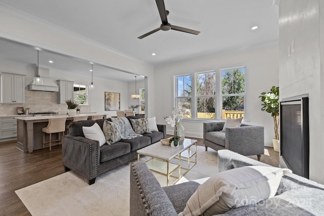 living area featuring recessed lighting, a healthy amount of sunlight, baseboards, and wood finished floors