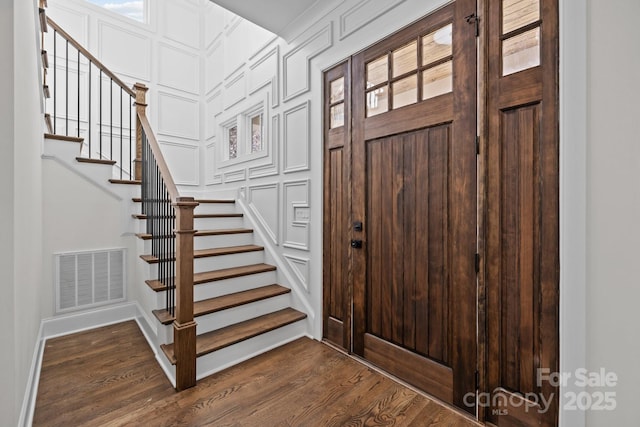 entryway featuring stairway, baseboards, visible vents, and dark wood-style flooring