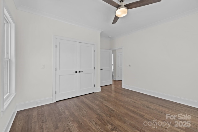 unfurnished bedroom with a closet, baseboards, ornamental molding, and dark wood finished floors