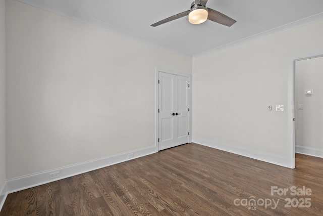 spare room featuring baseboards, wood finished floors, and a ceiling fan