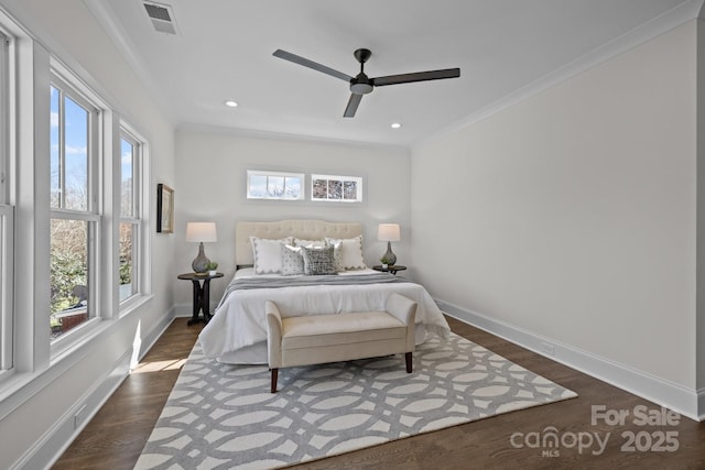 bedroom featuring visible vents, crown molding, dark wood-type flooring, baseboards, and a ceiling fan