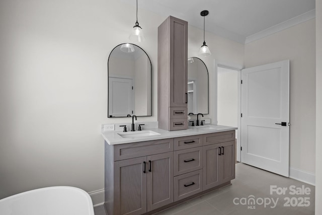 bathroom featuring a sink, a freestanding tub, double vanity, and crown molding