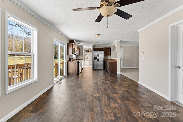 unfurnished living room featuring ceiling fan, crown molding, dark hardwood / wood-style floors, and a textured ceiling