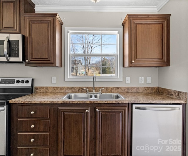 kitchen with ornamental molding, appliances with stainless steel finishes, and sink