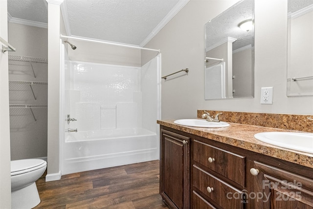 full bathroom featuring toilet, wood-type flooring, a textured ceiling, ornamental molding, and vanity