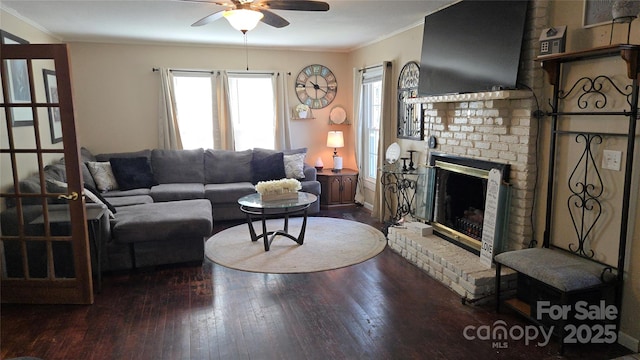 living room with hardwood / wood-style floors, ornamental molding, a brick fireplace, and ceiling fan