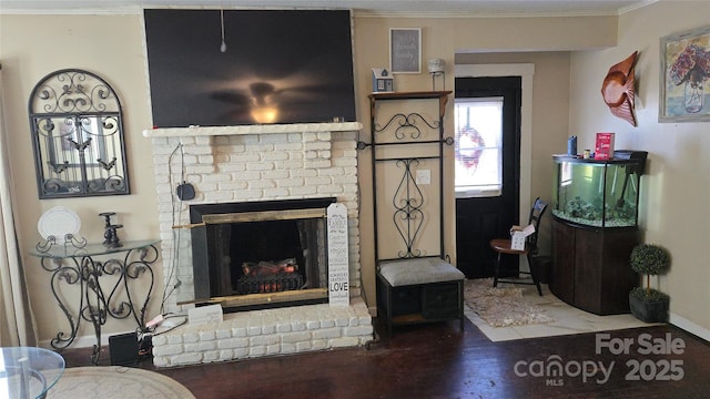 living room with hardwood / wood-style flooring, ornamental molding, and a brick fireplace