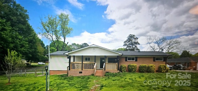 ranch-style house featuring fence, a porch, and a front yard