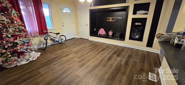 foyer entrance featuring visible vents, baseboards, and wood finished floors