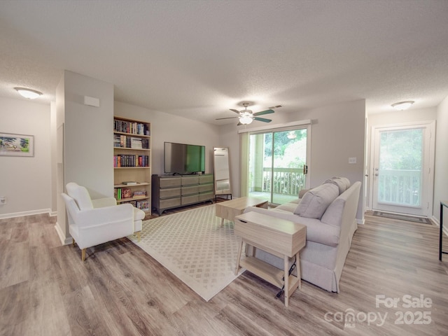 living room with a textured ceiling and light hardwood / wood-style floors