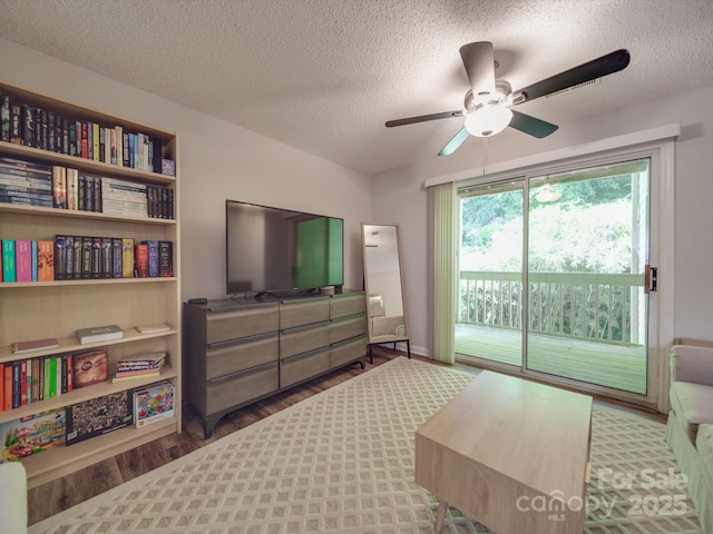 bedroom featuring access to exterior, hardwood / wood-style flooring, a textured ceiling, and ceiling fan