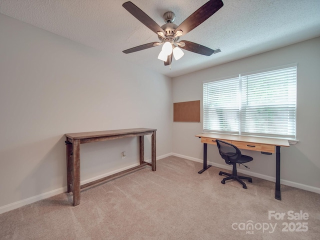 carpeted office featuring ceiling fan and a textured ceiling