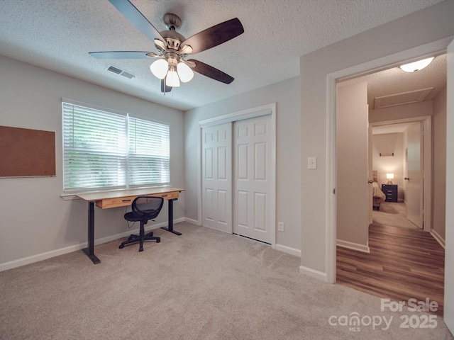 office space featuring light carpet and a textured ceiling