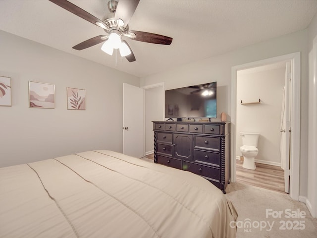 carpeted bedroom with connected bathroom and ceiling fan