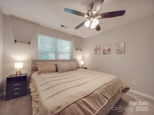 bedroom featuring ceiling fan, carpet floors, and a textured ceiling