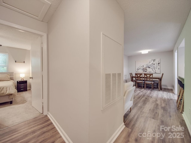 hallway with wood-type flooring and a textured ceiling