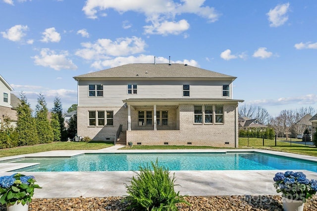 back of house featuring an outdoor pool, crawl space, brick siding, and a patio