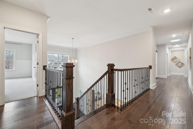 hallway featuring visible vents, an upstairs landing, wood finished floors, a chandelier, and baseboards