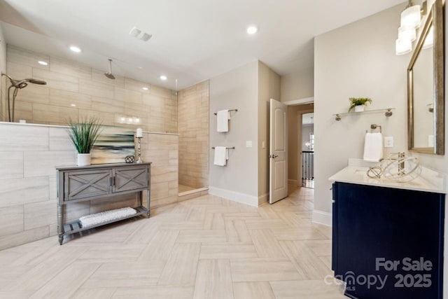 bathroom with recessed lighting, vanity, baseboards, and a walk in shower