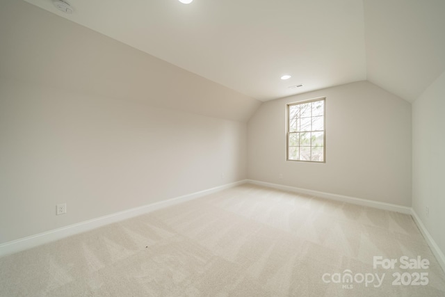 additional living space with lofted ceiling and light colored carpet