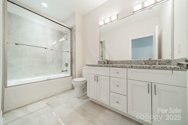 full bathroom with vanity, shower / bath combination with glass door, and toilet