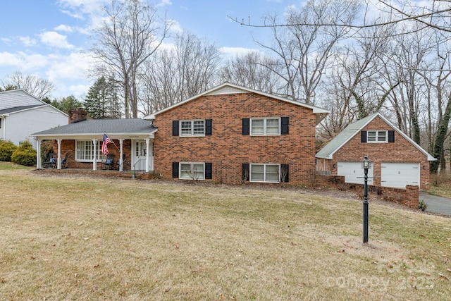 tri-level home with covered porch and a front yard