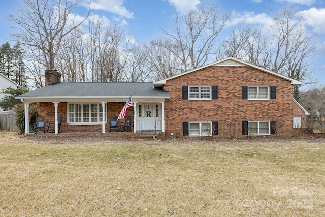 tri-level home featuring a porch and a front lawn