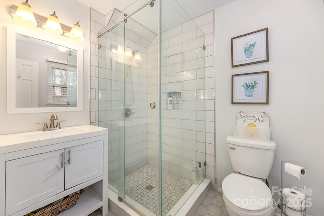 bathroom featuring vanity, an enclosed shower, and toilet