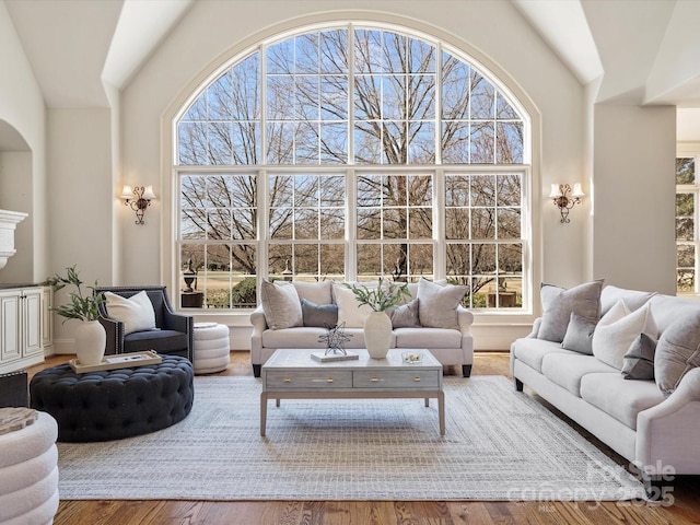 living room with high vaulted ceiling and wood finished floors