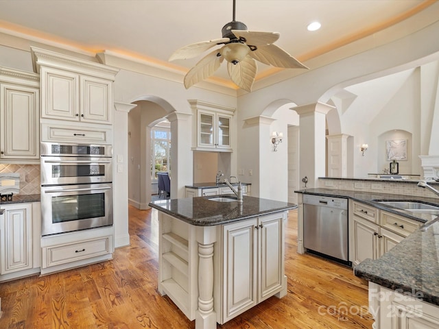 kitchen featuring stainless steel appliances, a sink, and cream cabinets