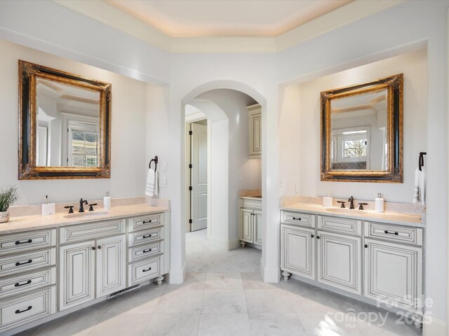 bathroom with two vanities, a sink, and baseboards