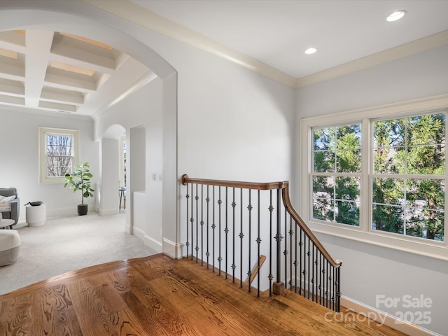 hallway with arched walkways, recessed lighting, wood finished floors, coffered ceiling, and baseboards