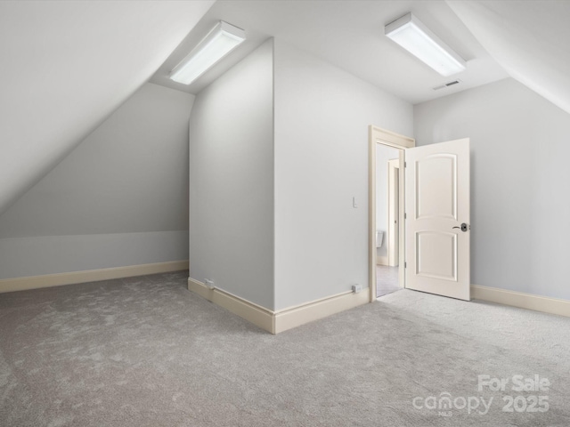 bonus room featuring lofted ceiling, carpet floors, baseboards, and visible vents