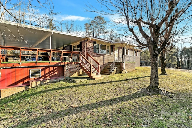 rear view of property featuring a wooden deck and a lawn