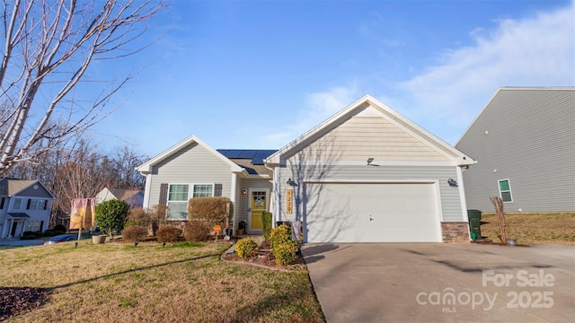 view of front of property with a front lawn, solar panels, and a garage