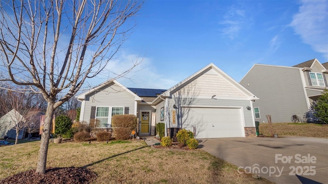 view of front of home with a garage, solar panels, and a front lawn