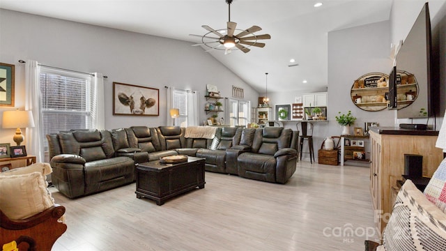 living room with high vaulted ceiling, ceiling fan, and light hardwood / wood-style flooring