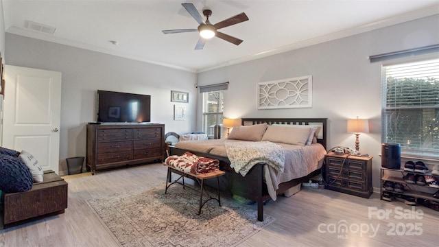 bedroom with light wood-type flooring, ornamental molding, and ceiling fan