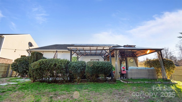 rear view of house with an outdoor living space, a lawn, and a gazebo