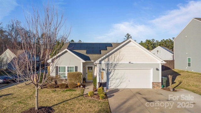 view of front property featuring solar panels, a front yard, and a garage