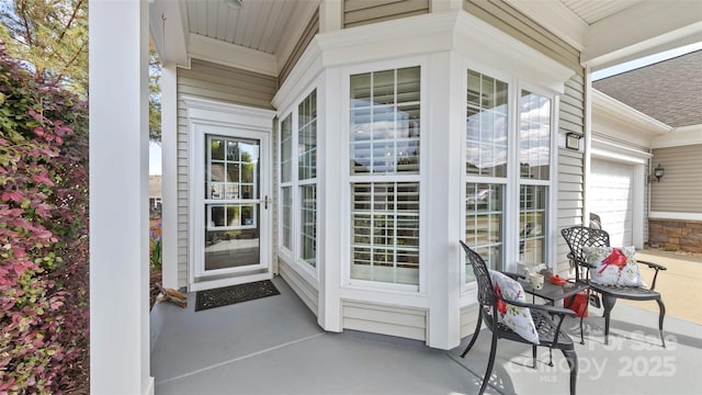 property entrance with a porch, a shingled roof, and an attached garage