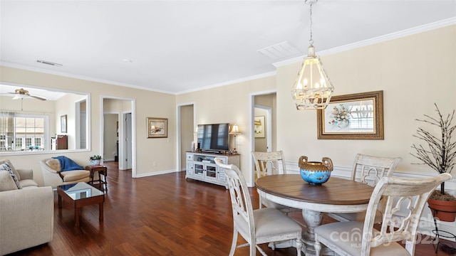 dining room with ornamental molding, a notable chandelier, dark wood-style floors, and visible vents